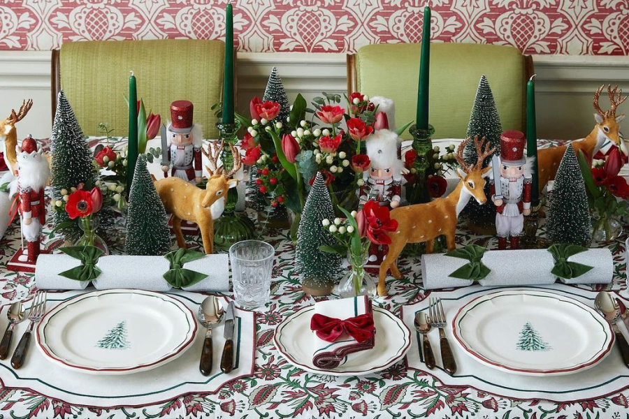 Festive Christmas table setup with red napkins and pine décor.