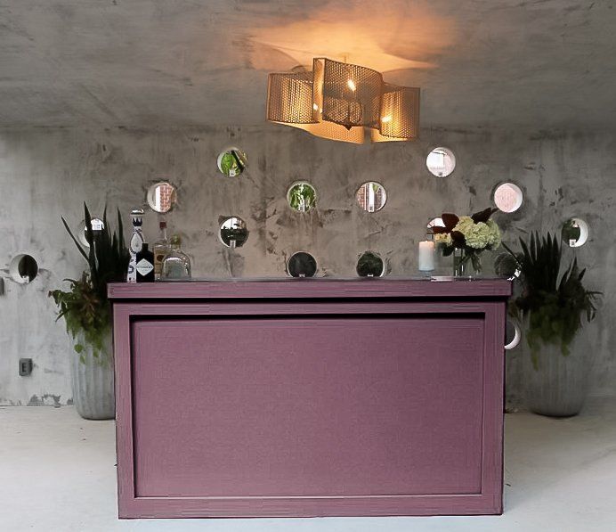 Mauve-colored bar structure ready for drinks service.
